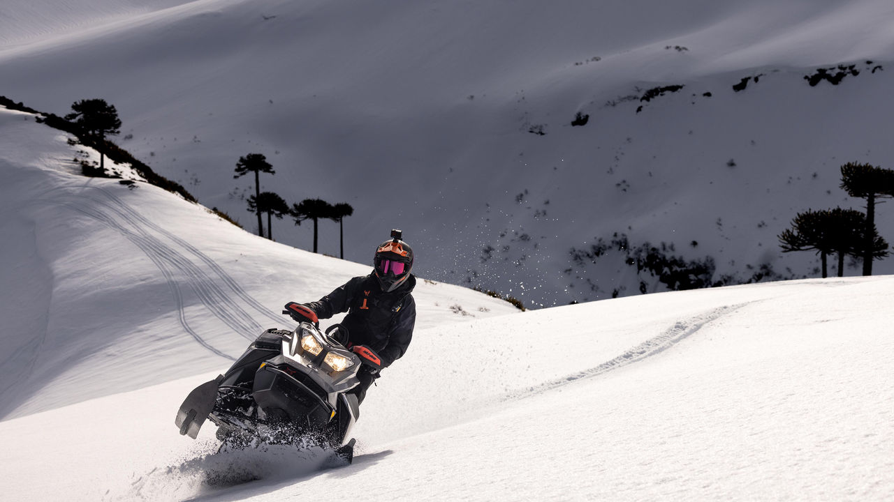 Muž jazdí na Ski-Doo v hlbokom snehu v Chile