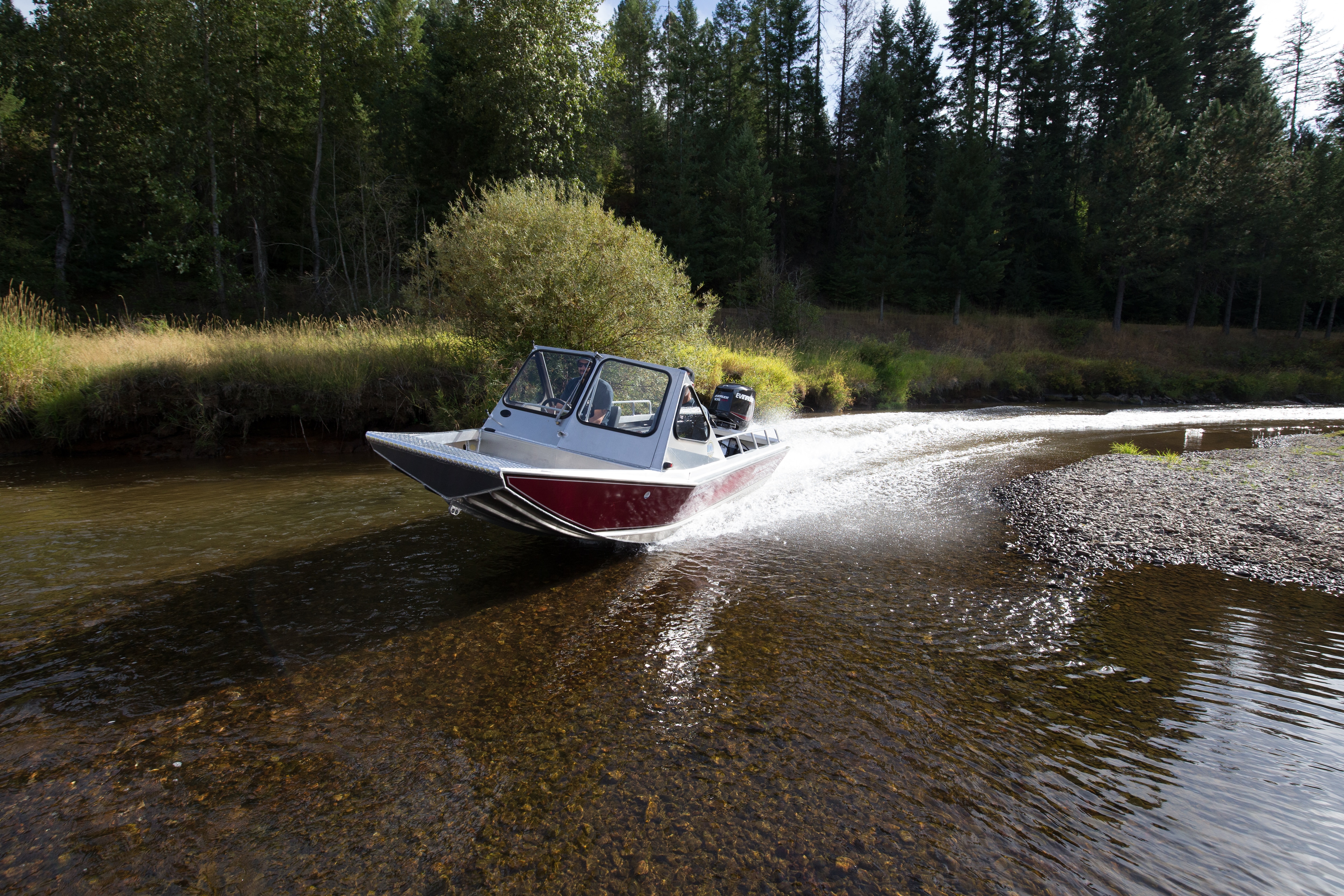 Man driving small boat across shallow water