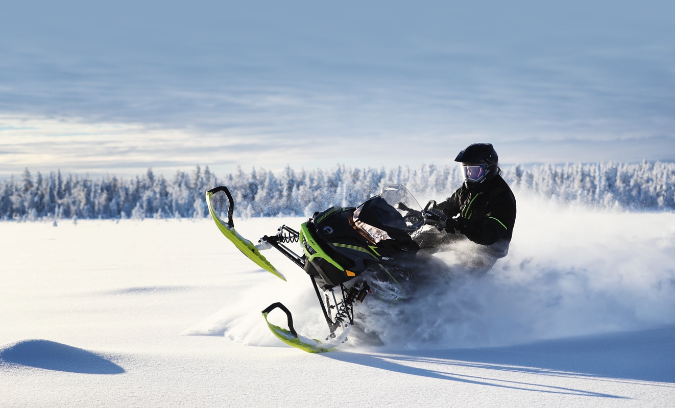 A man drifts in the snow with his Lynx Xterrain Snowmobile Model