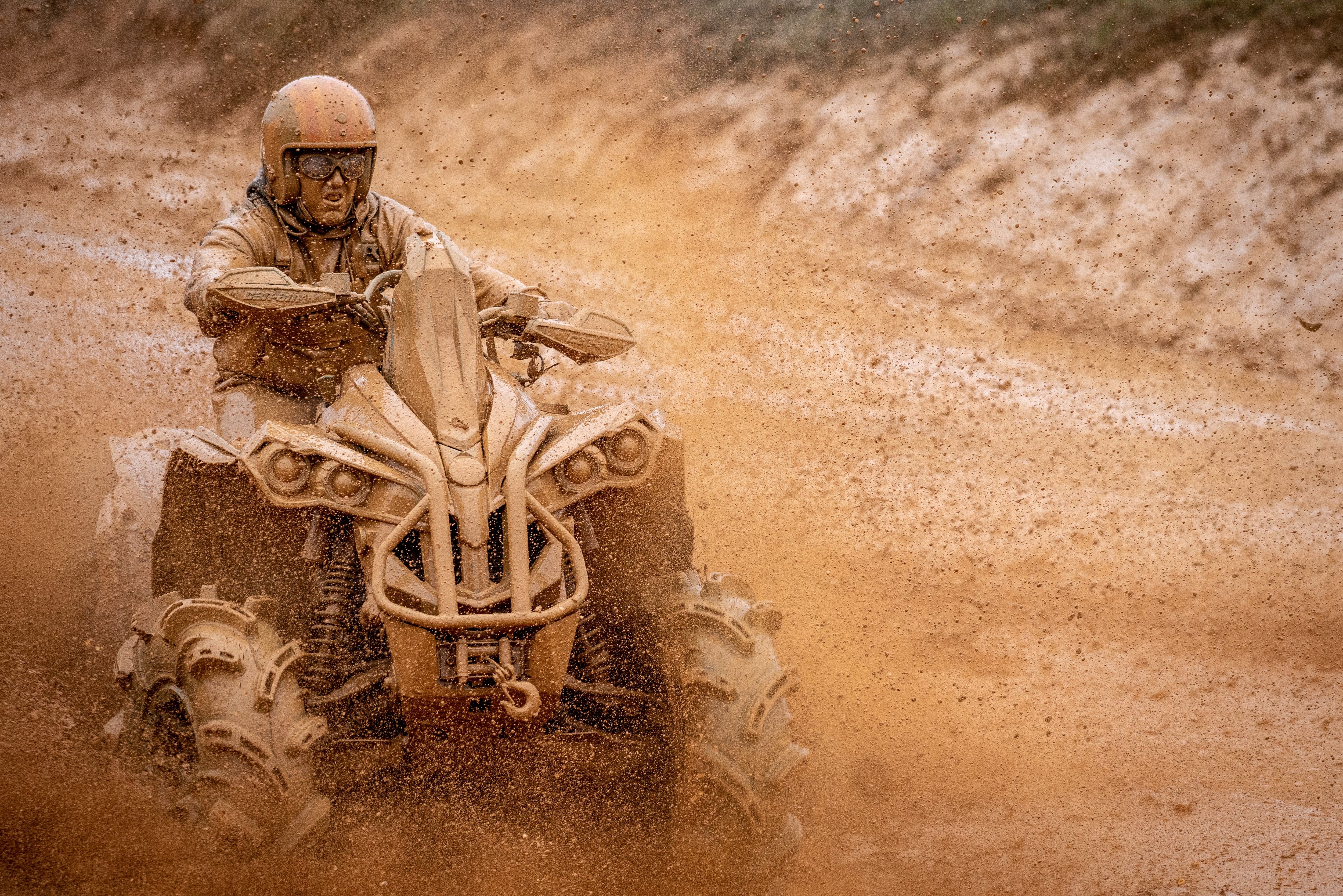  Čovjek prekriven blatom vozi svoj Renegade ATV po blatnjavoj stazi