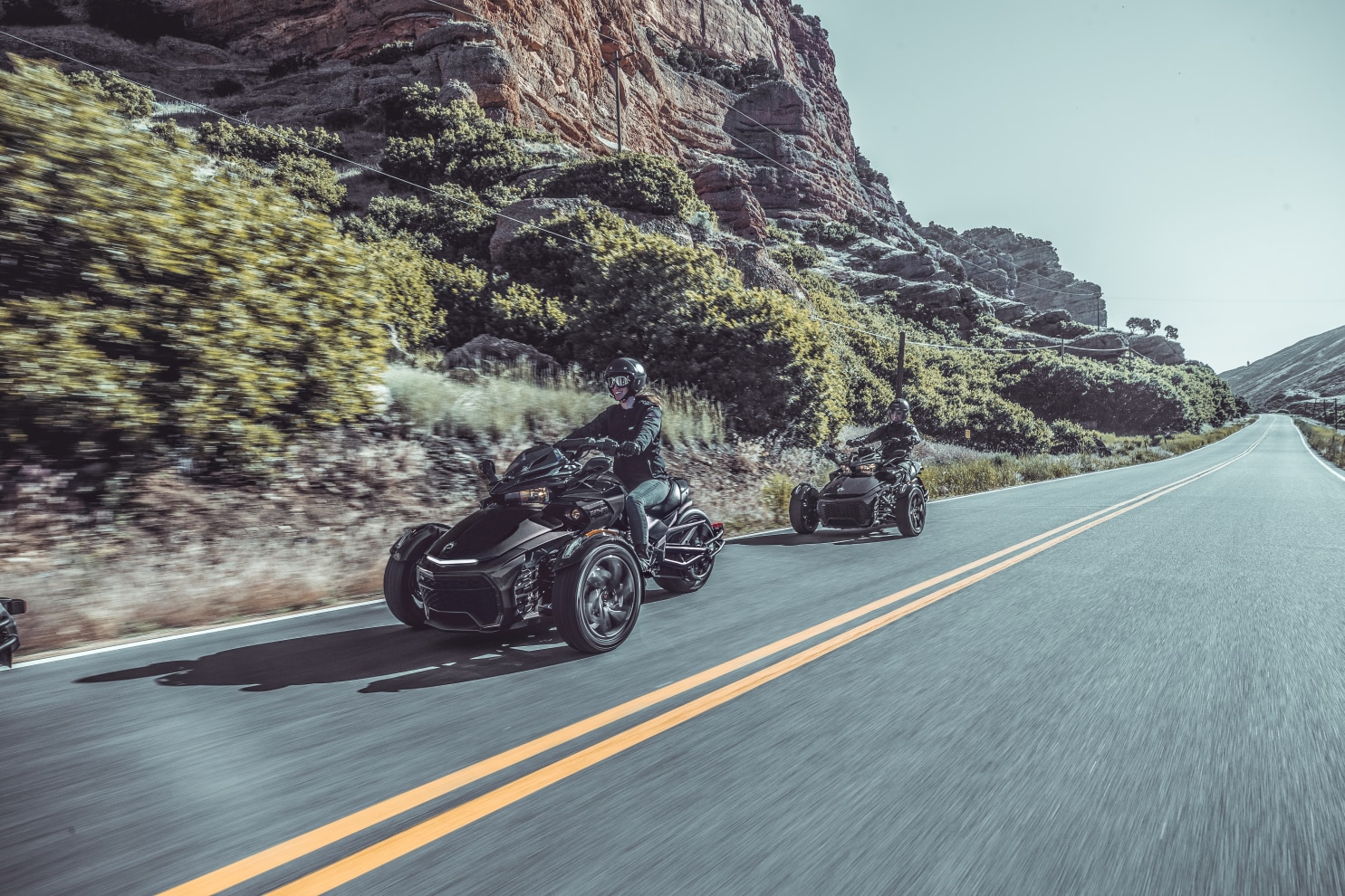 Two people driving their Spyder F3 on a scenic route