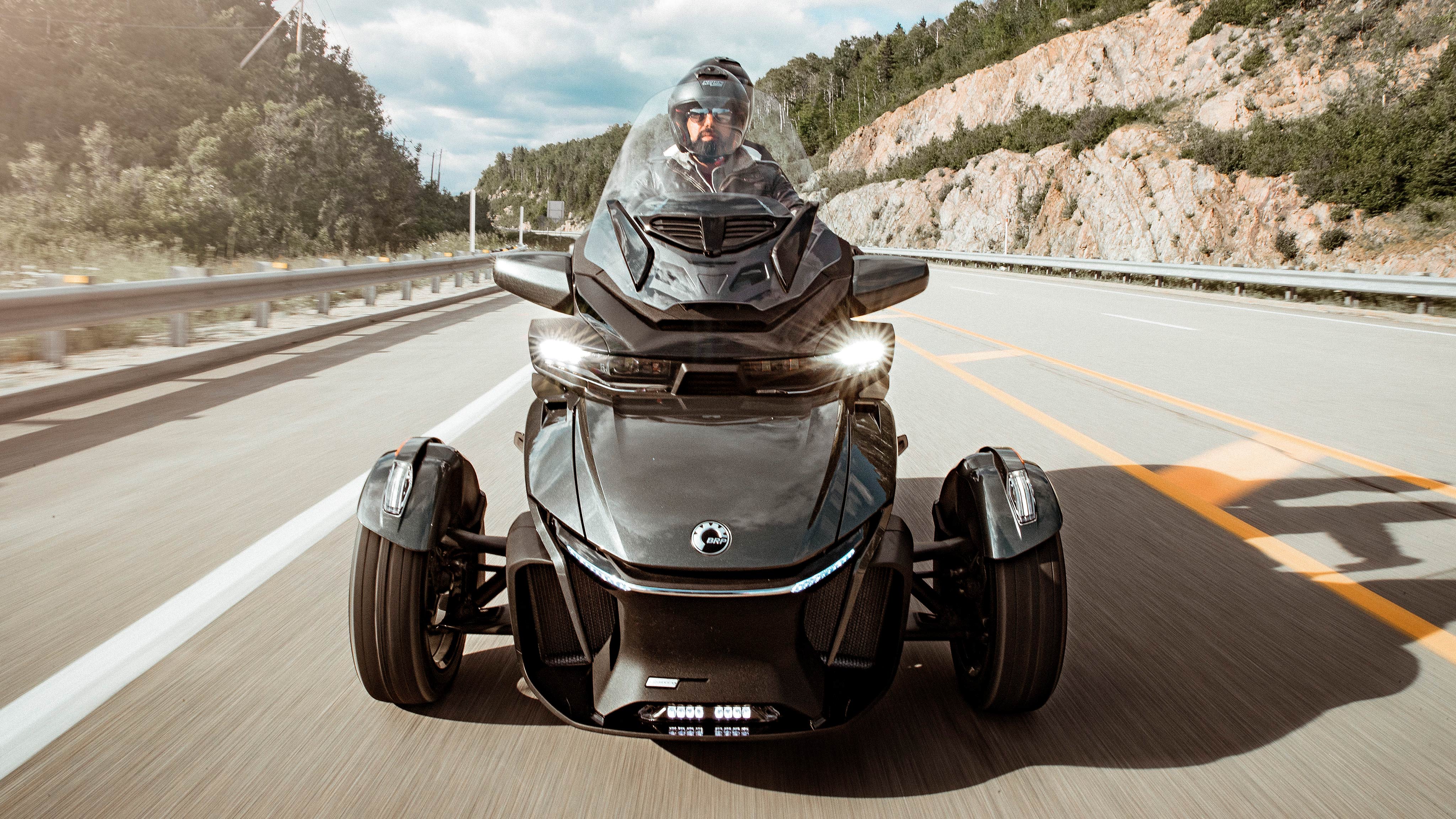 A couple driving a Can-Am Spyder RT on the road