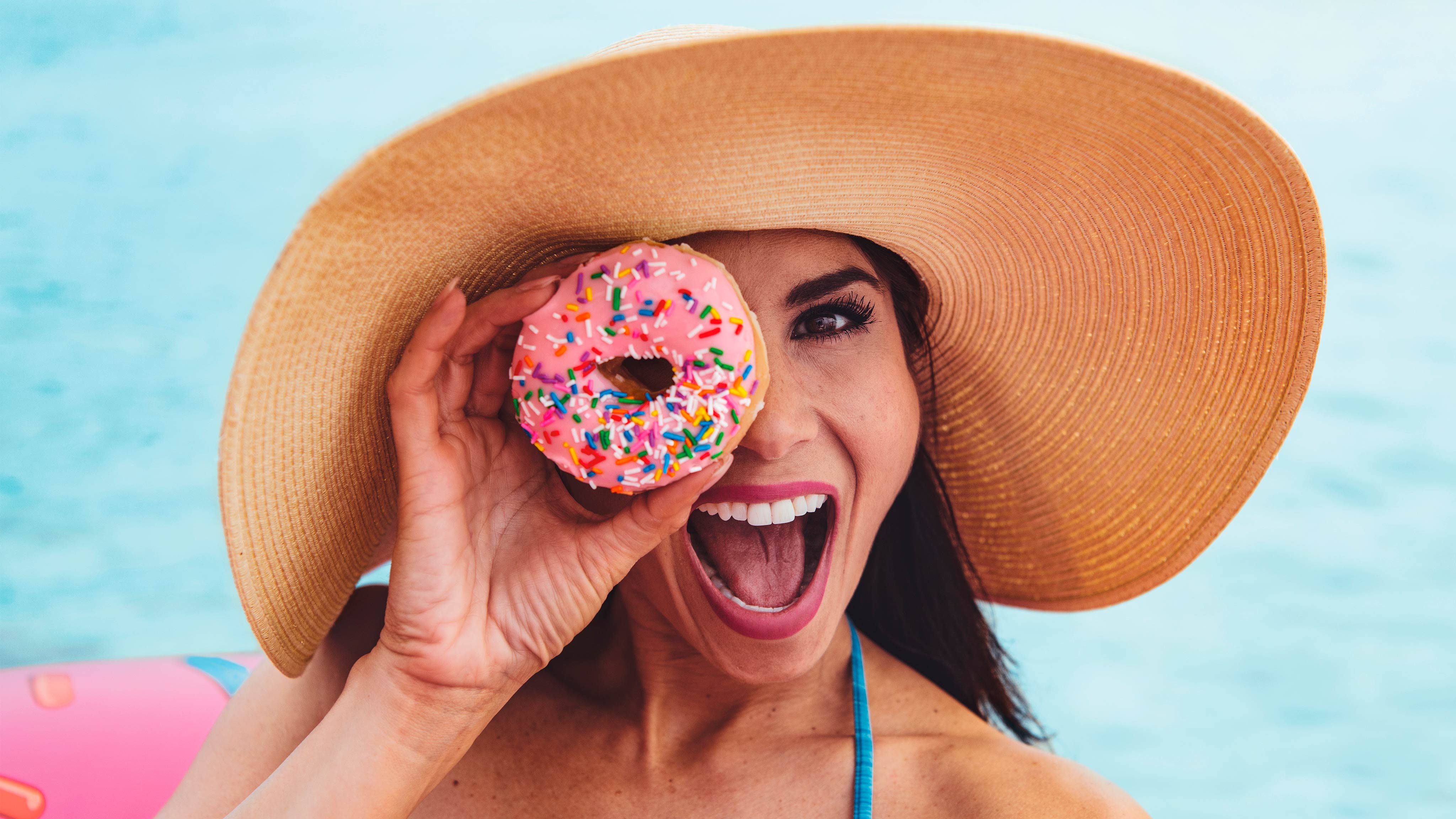  Gruaja e qeshur ndërsa mban një donut