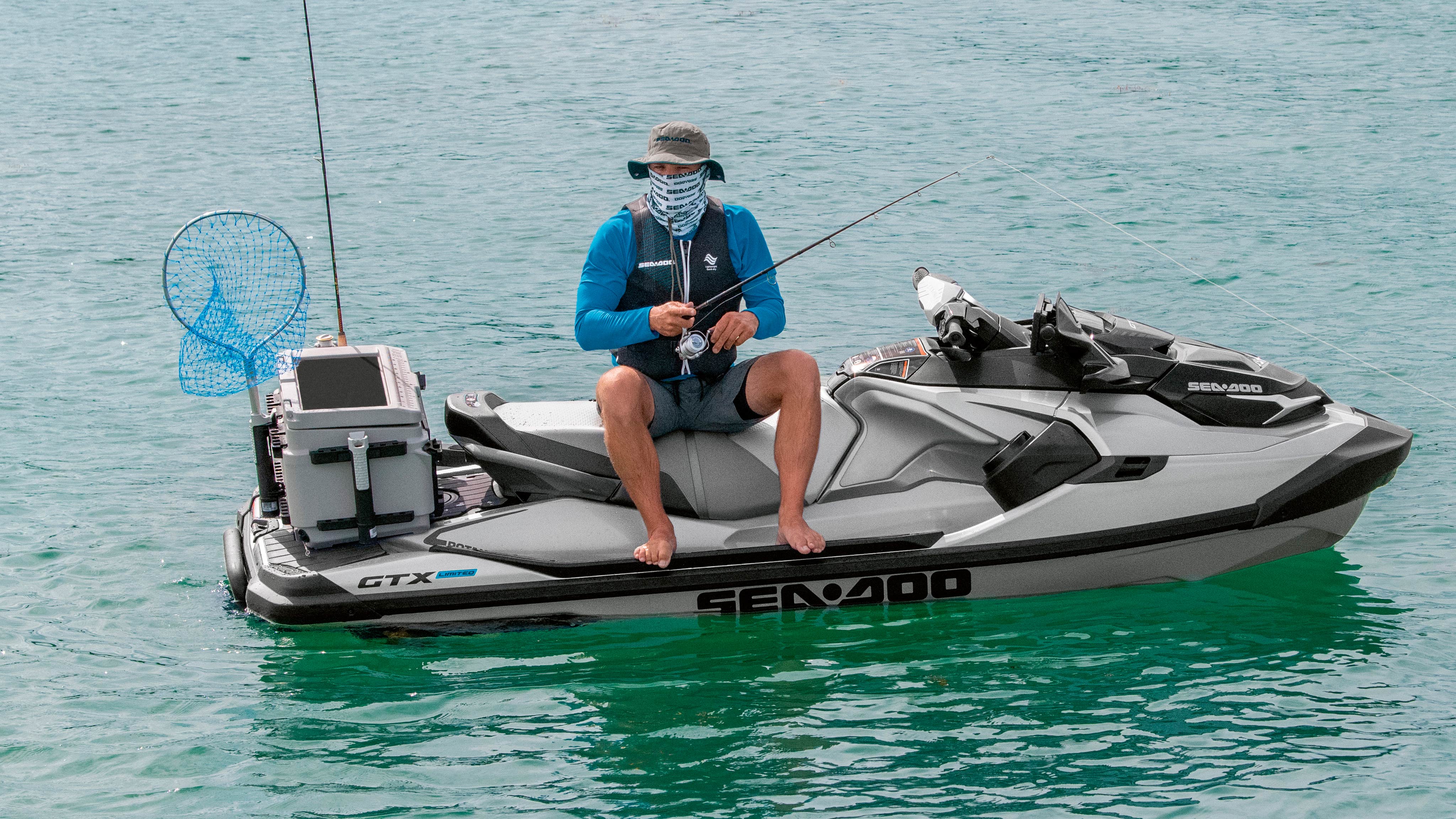  Človek lovi, medtem ko sedi na svojem Sea-Doo GTX Limited Edition