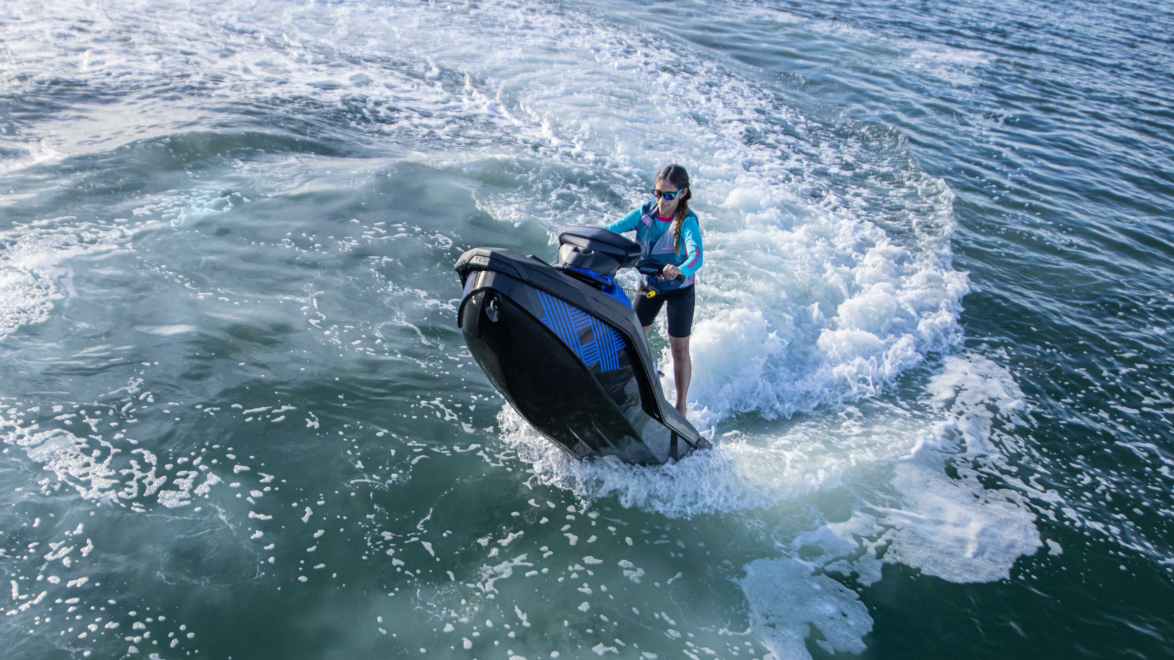 Gruaja duke bërë një qiri mbi Sea-Doo Spark Trixx e saj blu
