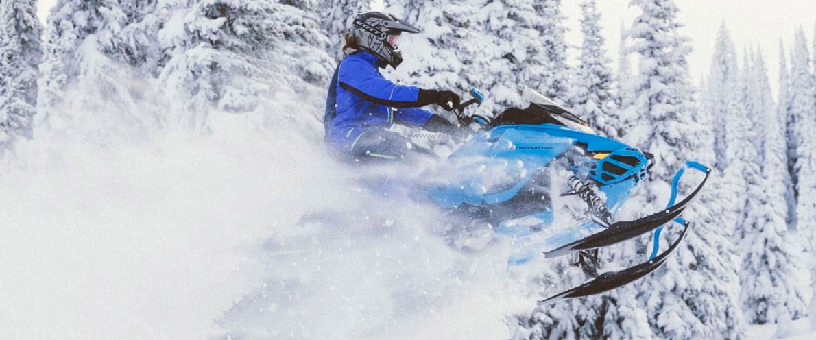  Njeriu duke kërcyer nëpër dëborë me sajë me motor të tij Renegade