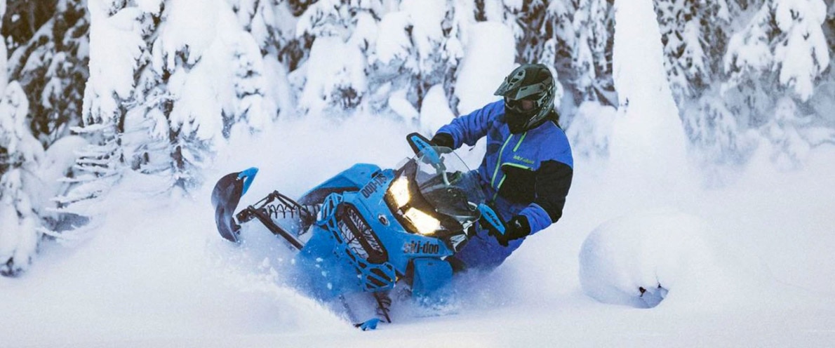  Njeriu që kalon nëpër dëborë në sajë me motor të tij Renegade
