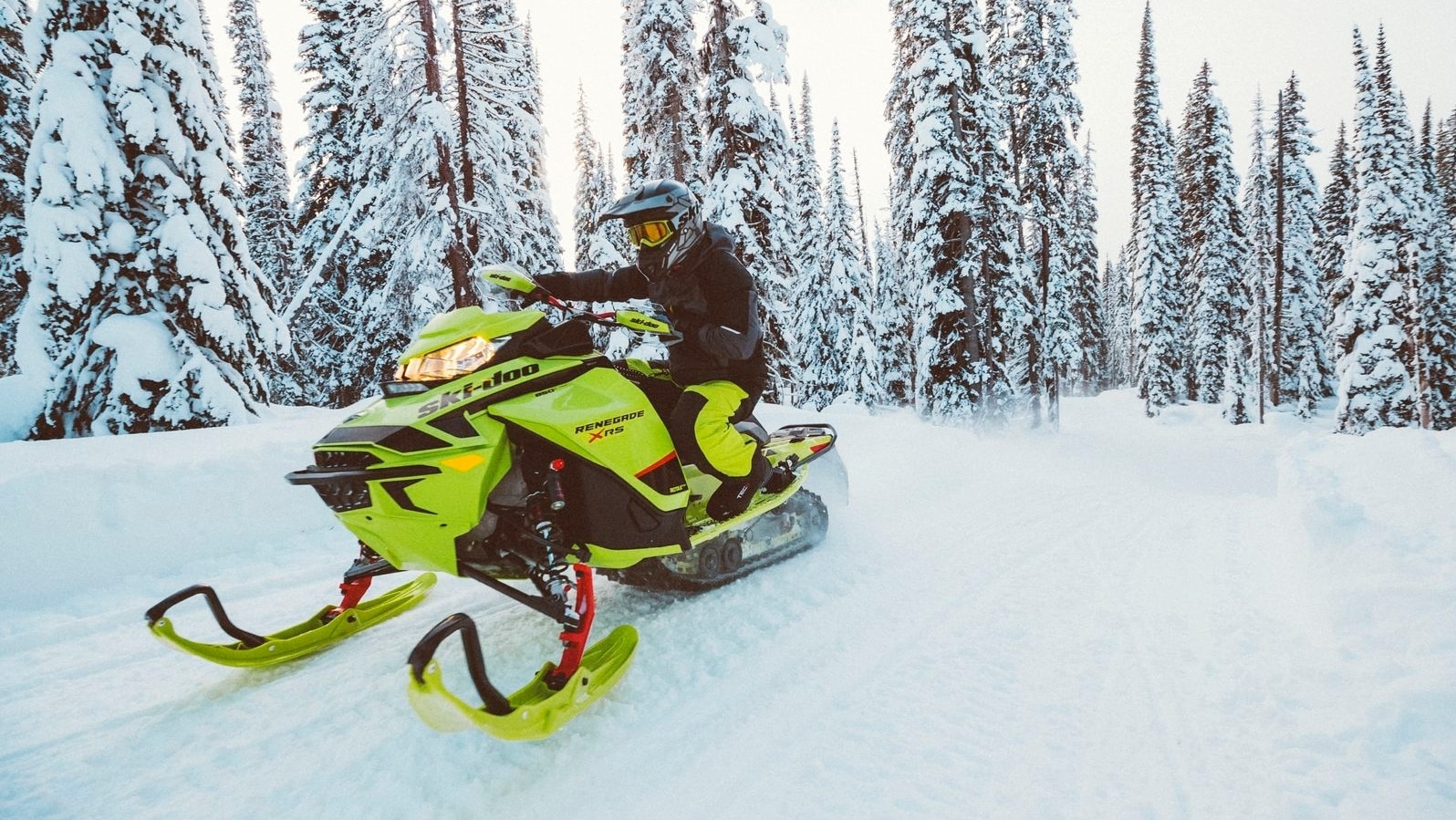 Njeriu duke vozitur nëpër dëborë me sajë me motor të tij Ski-Doo Renegade