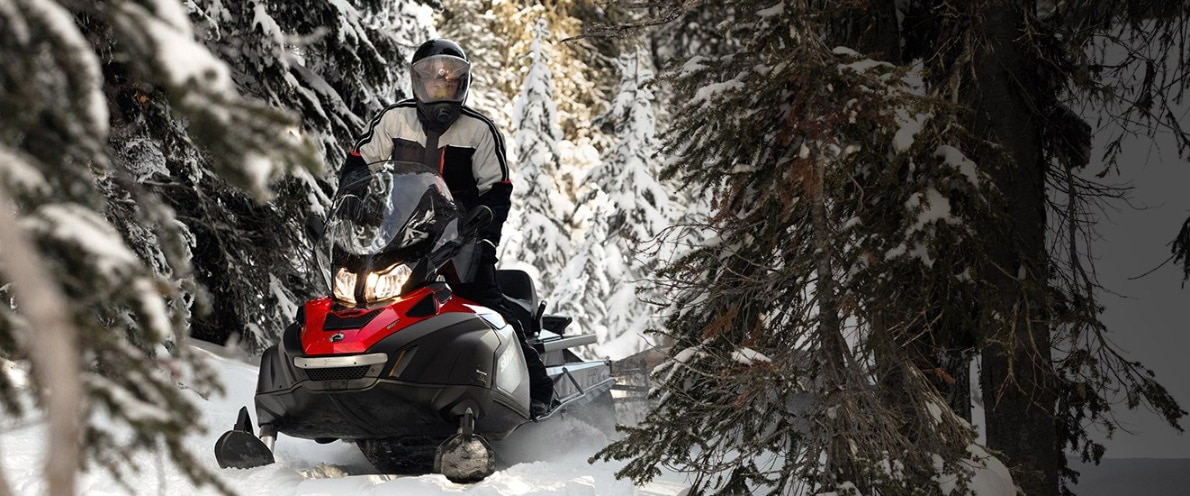 Čovjek vozi Skandićeve motorne sanke kroz snježnu šumu