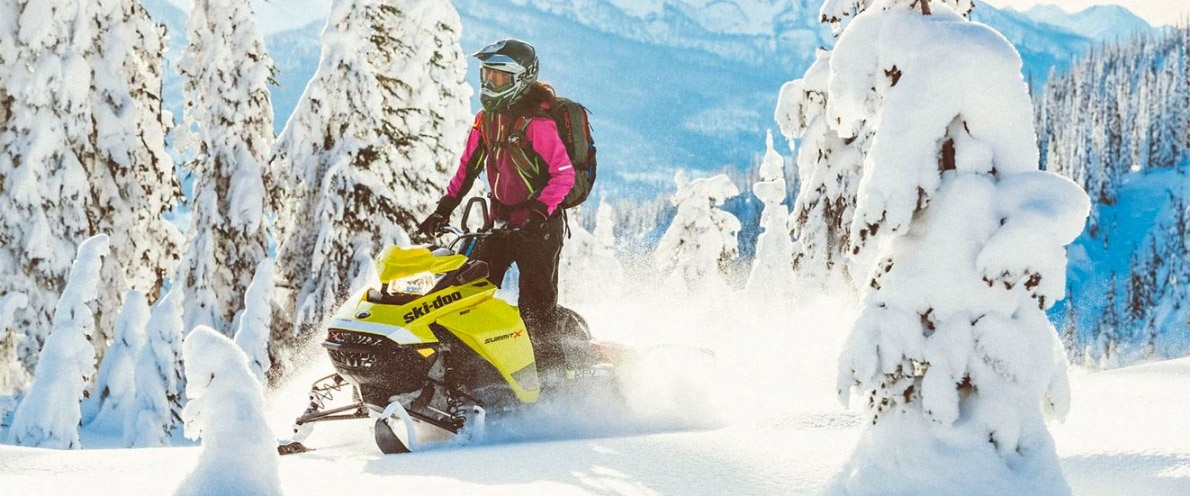  Žena ustaje dok vozi svoj Ski-Doo samit
