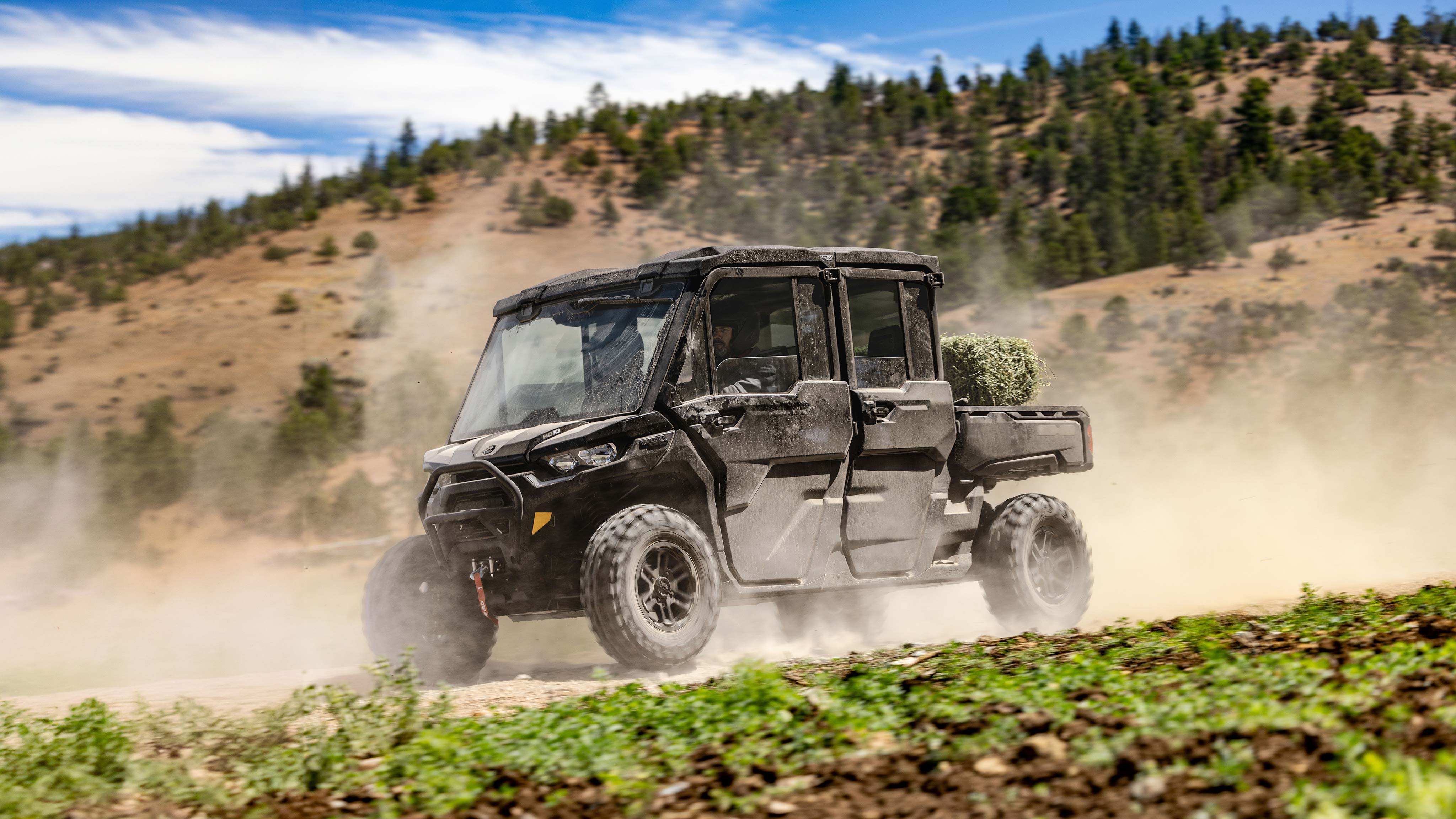 Rider reaching for a LinQ storage box in the back of his 2024 Can-Am Maverick R SxS