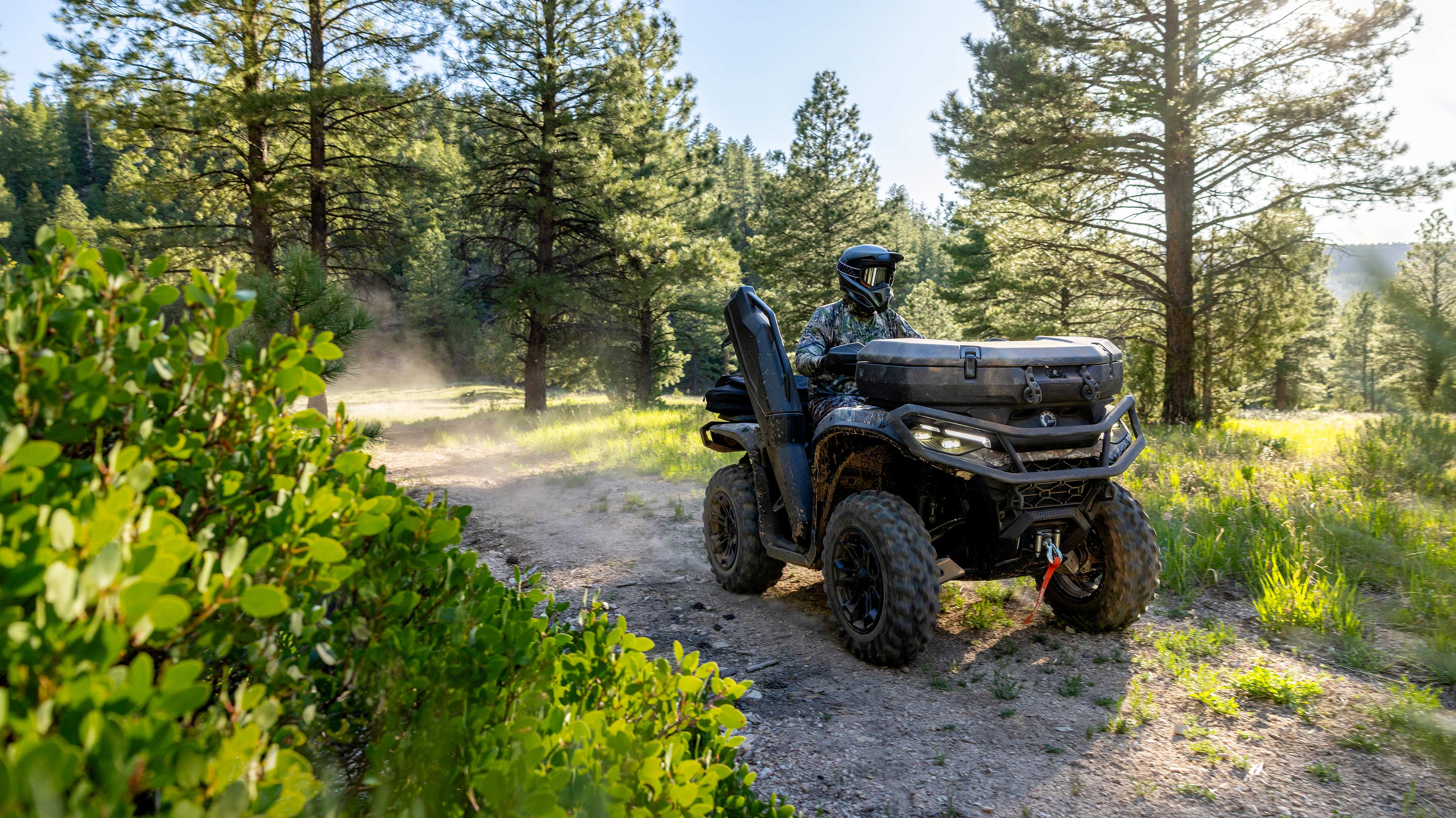 Vozač vozi Can-Am Outlander ATV na prašnjavom putu