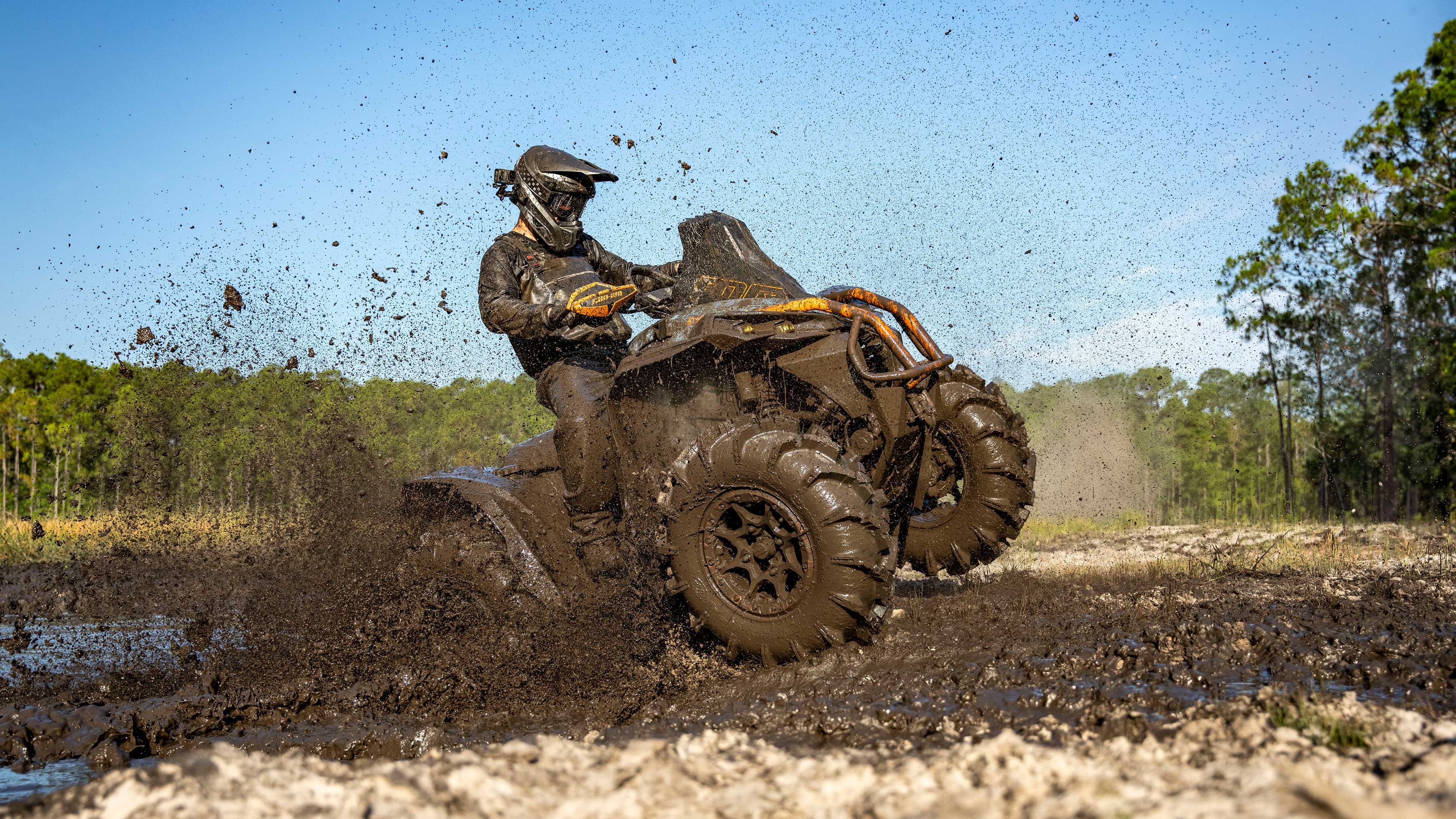 A man in the desert with his Can-Am Maverick R SxS in the background