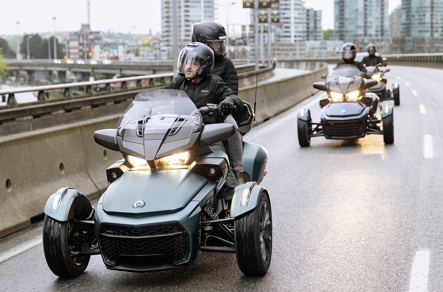 A man and a woman riding Can-Am Spyder 2023 near the lake