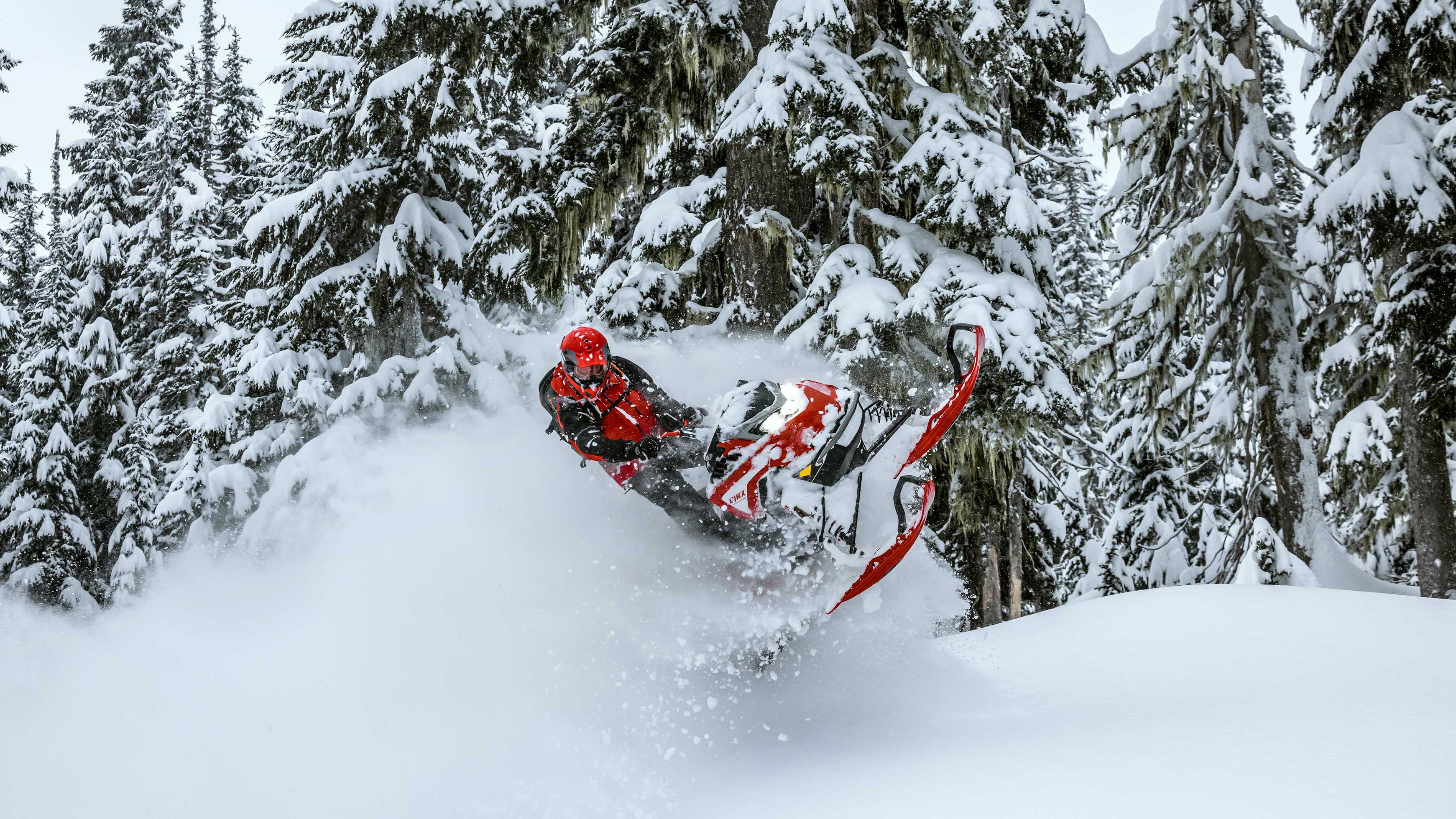 Возење на Lynx моторни санки низ планинскиот длабок снег.