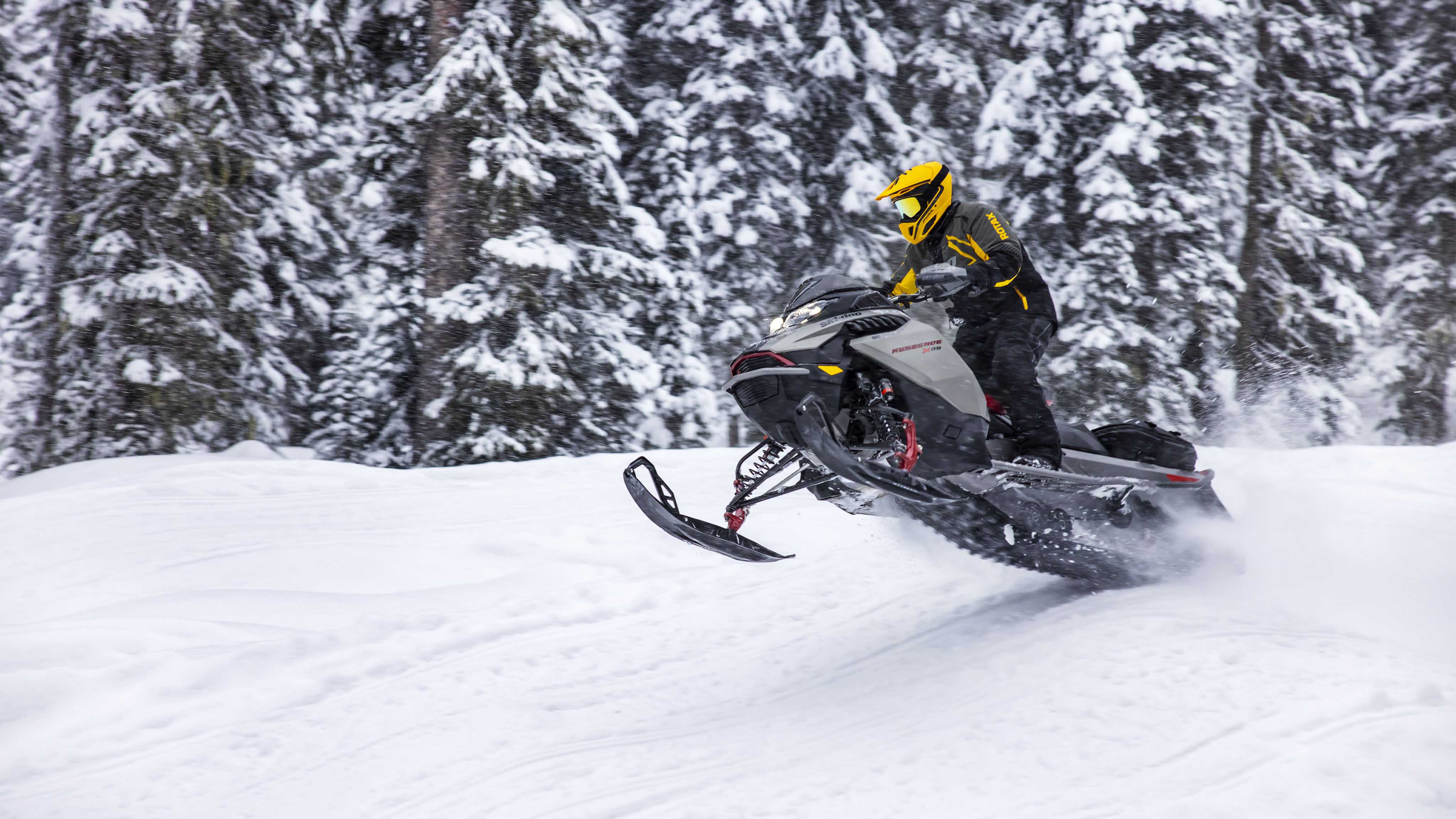 Muž jazdí rýchlo na traili pre snežné skútre Ski-Doo Renegade