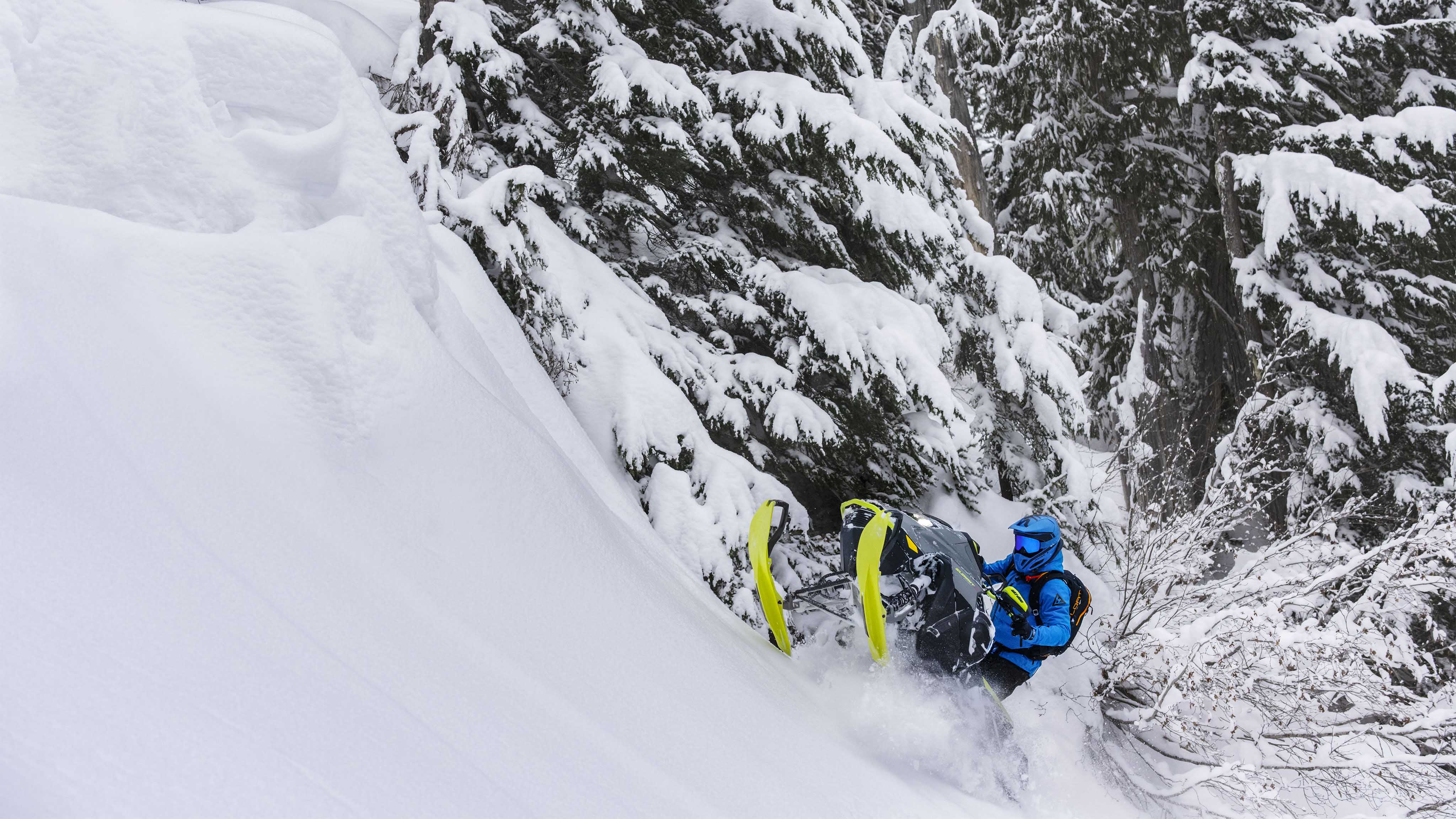 Mężczyzna jadący w głębokim śniegu na nowym skuterze śnieżnym Ski-Doo Summit 2023
